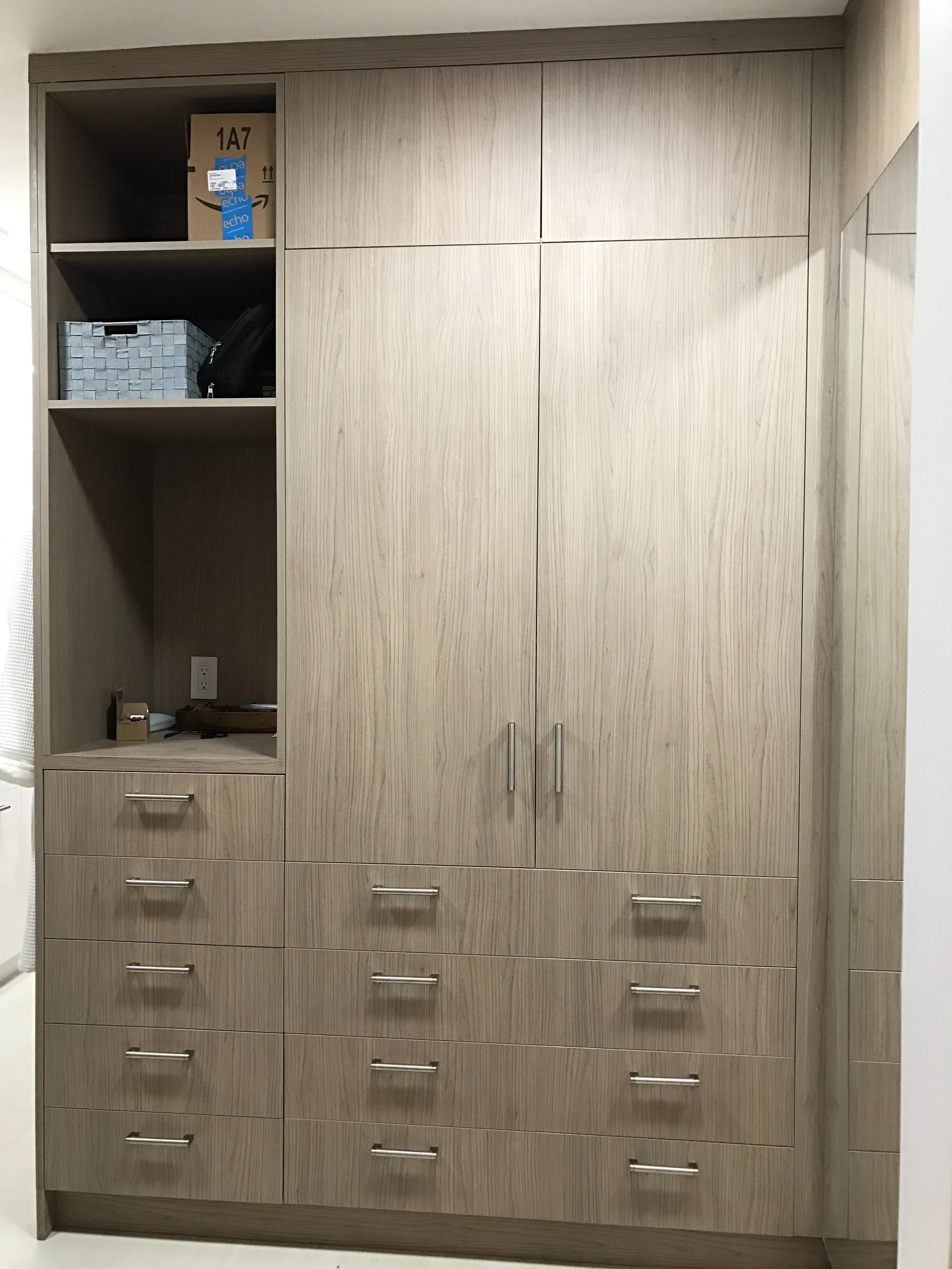 Finished custom closet built-in with wood grain doors and drawers