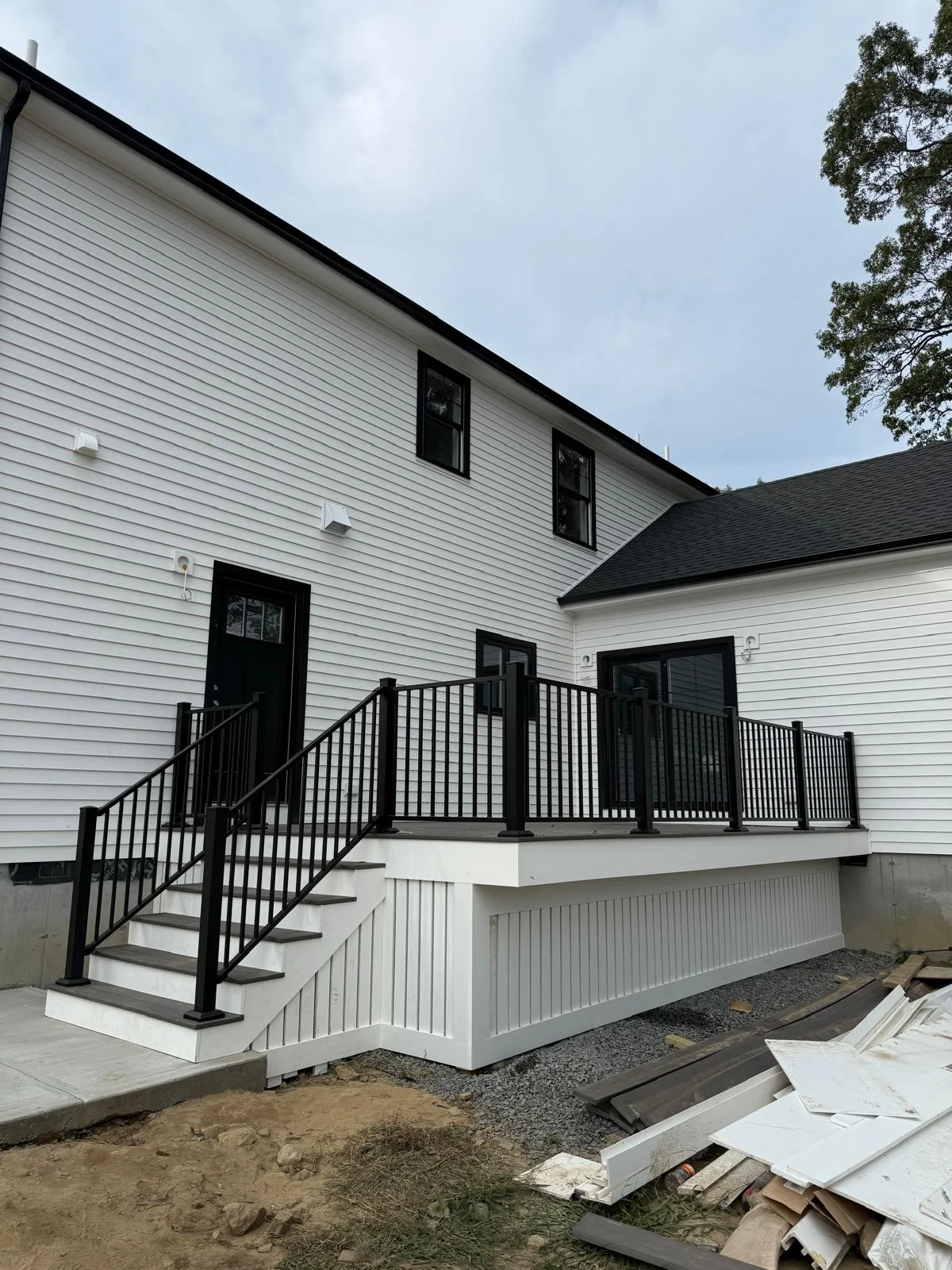 Wide view of a finished backyard deck with black railings
