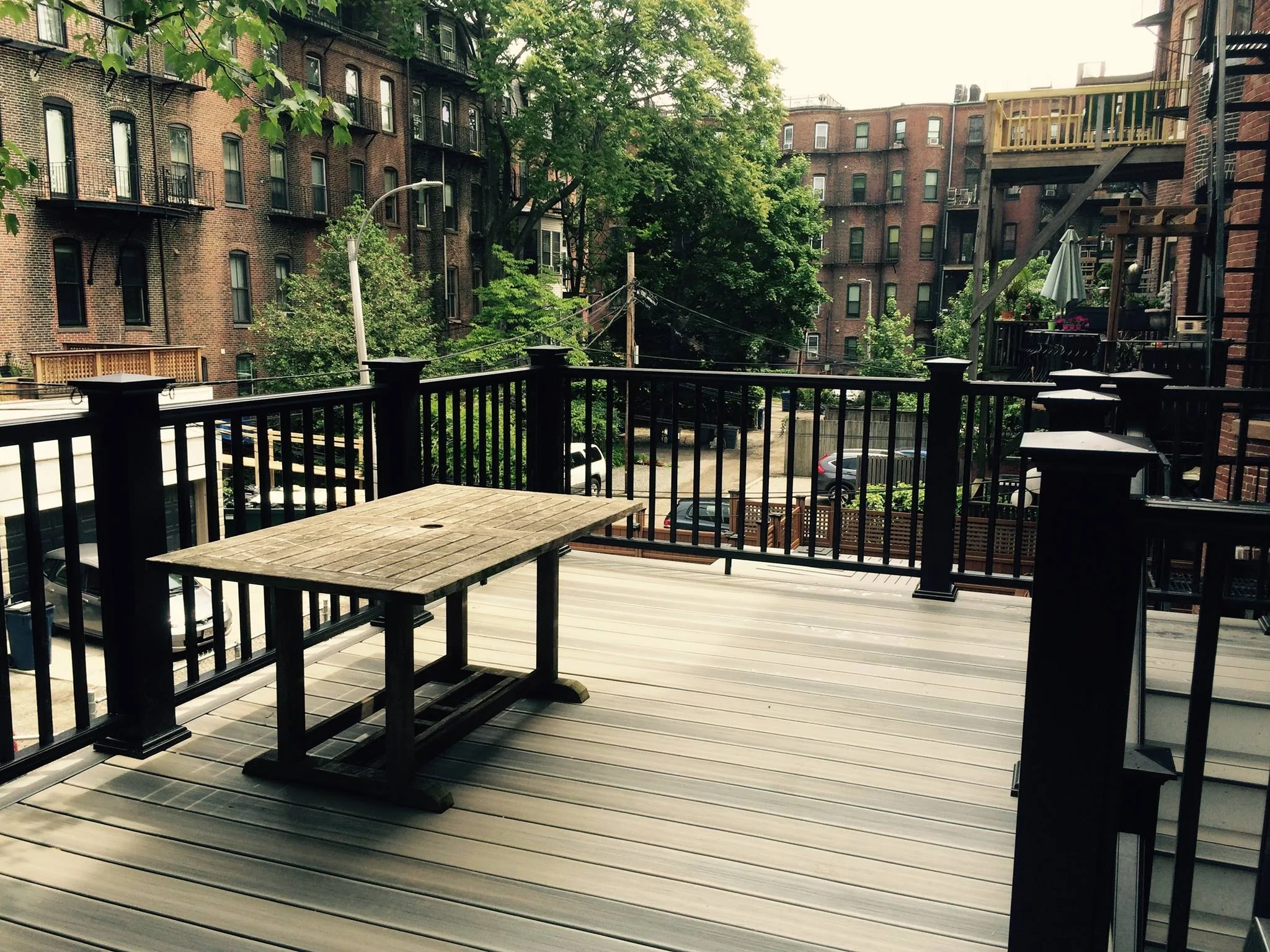 Finished rooftop deck with black railings and outdoor seating