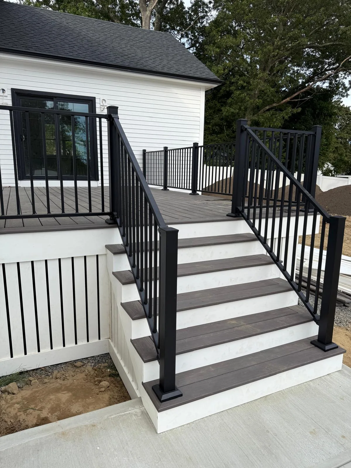 Composite deck stairs with white risers and black aluminum railings